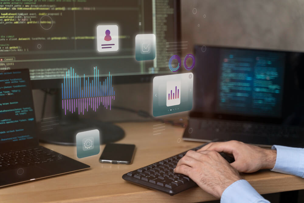 Person coding with digital icons on screen.